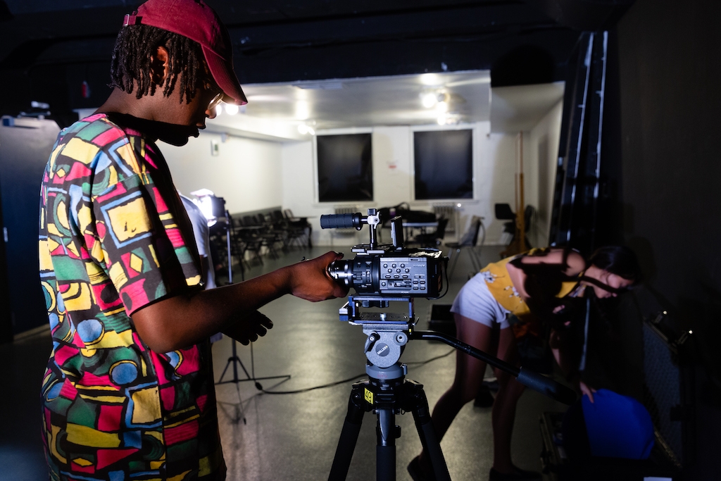 Film students working with cameras in a film studio